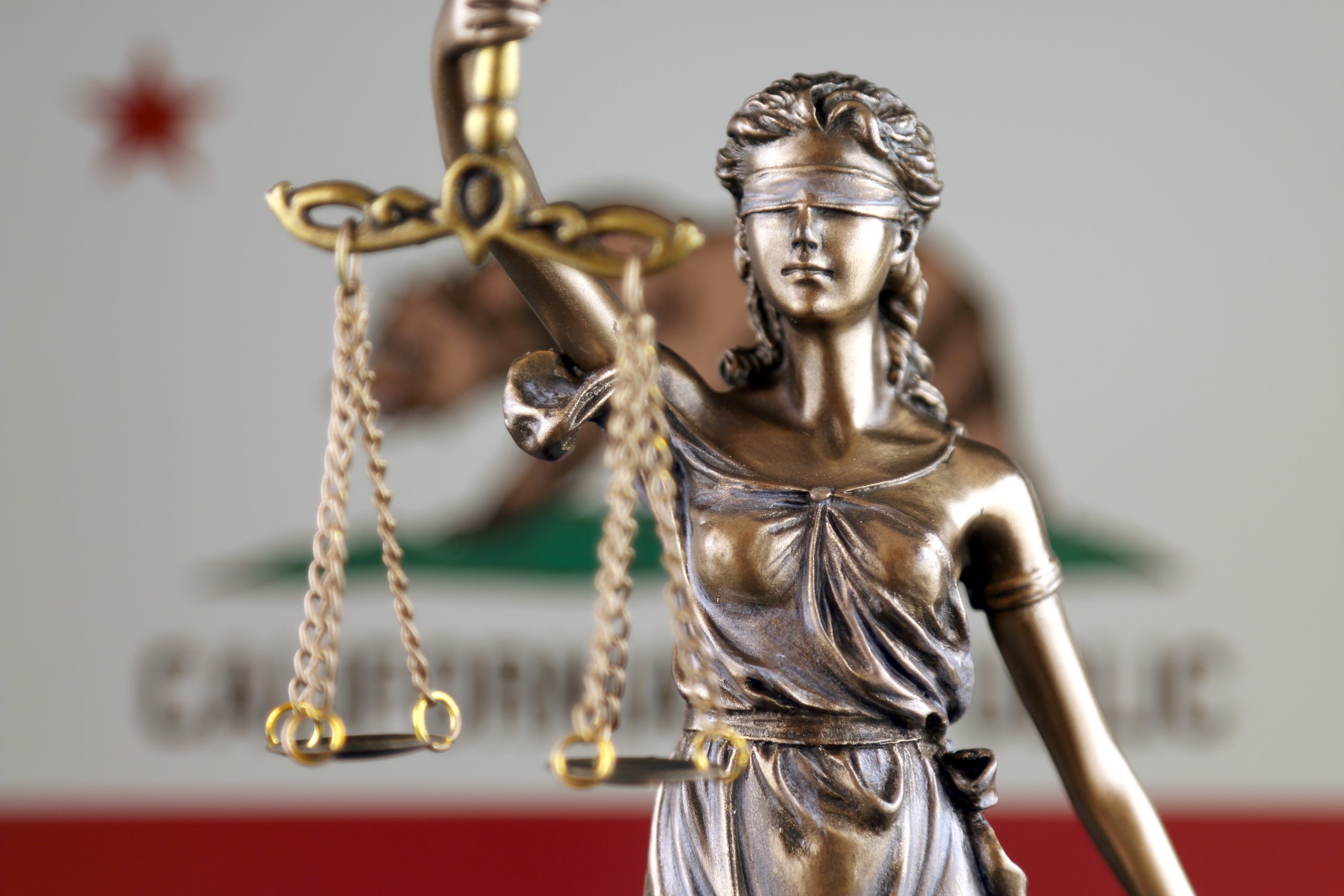 Symbol of law and justice with California State Flag. Close up. Deposition Times now limited in California